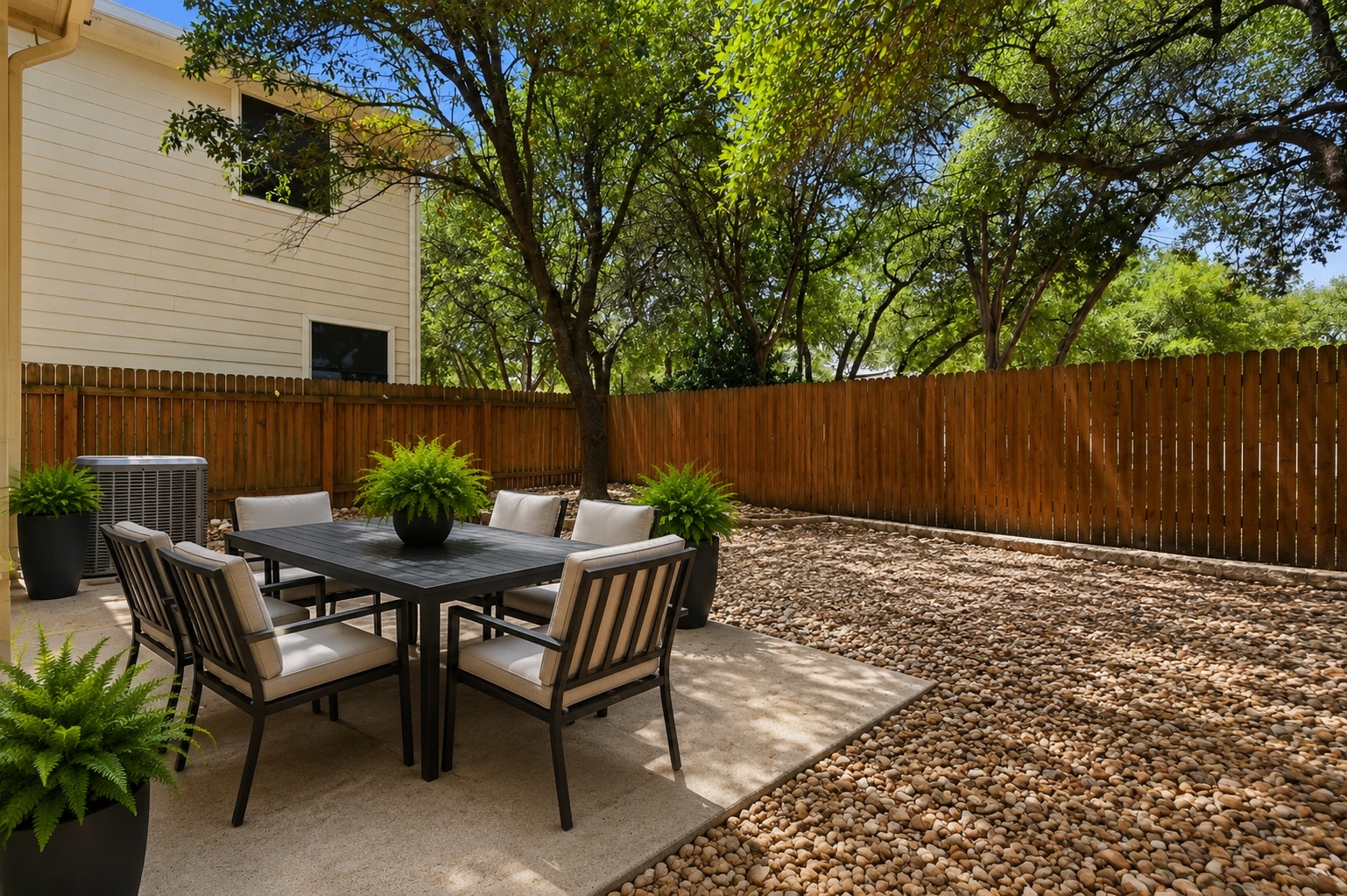 4508 Duval Road, Unit 4401 Austin, TX 78727 - Photo 20 of 26 Mature trees shade a private concrete patio bordered by a wooden privacy fence.