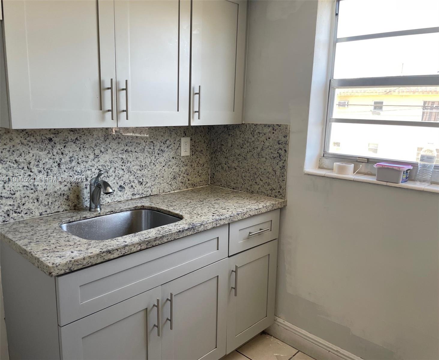 1787 Southwest 7th Street, Unit 7 Miami, FL 33135 - Photo 5 of 9 a kitchen with stainless steel appliances granite countertop a sink and a white cabinets