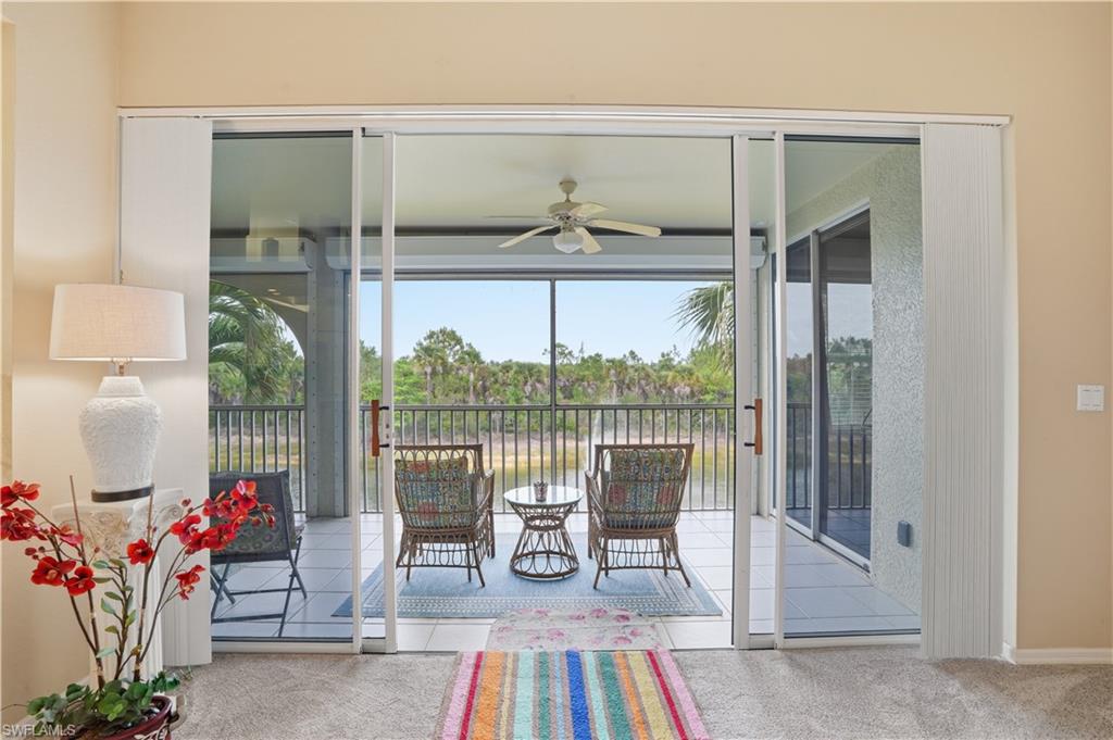10871 Crooked River Road, Unit 202 Estero, FL 34135 - Photo 18 of 46 a living room with furniture and a floor to ceiling window