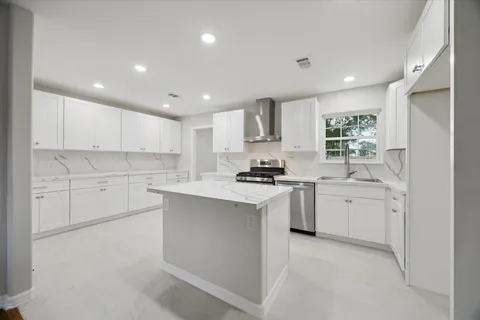 a kitchen with white cabinets and appliances