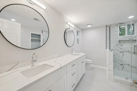 a bathroom with a double vanity sink mirror and bathtub