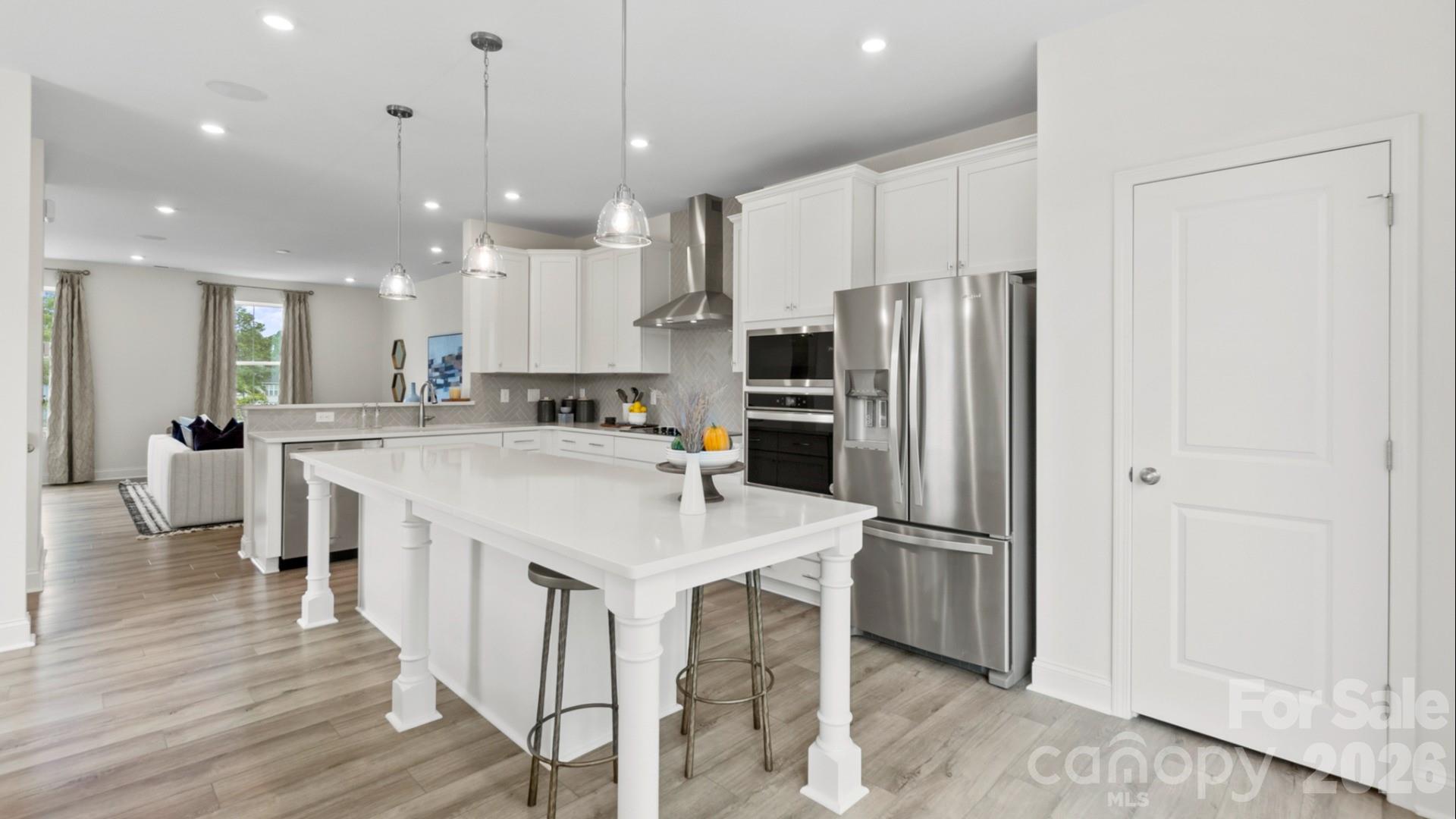 a large kitchen with a center island appliances wooden floor and a counter top space
