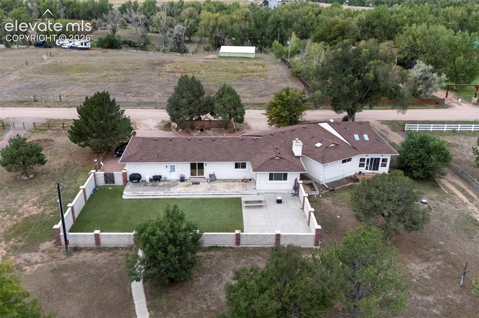8170 Valli Farm Road Fountain, CO 80817 - Photo 43 of 50 White exterior residence with a brown shingle roof, multiple skylights, and a chimney