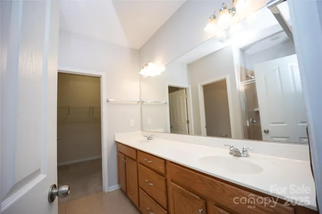 a bathroom with a bathtub a double vanity sink and mirror