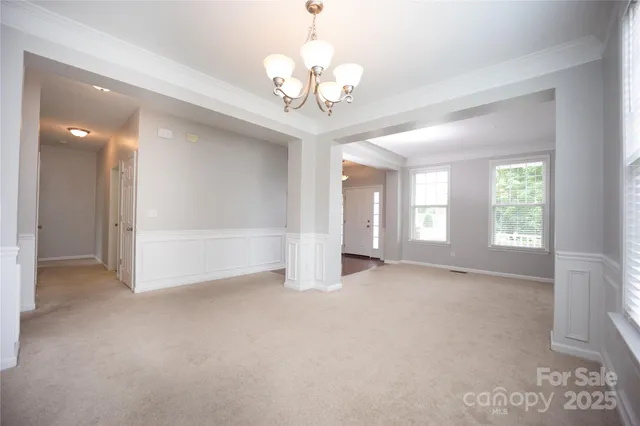 a view of a big room with windows and chandelier