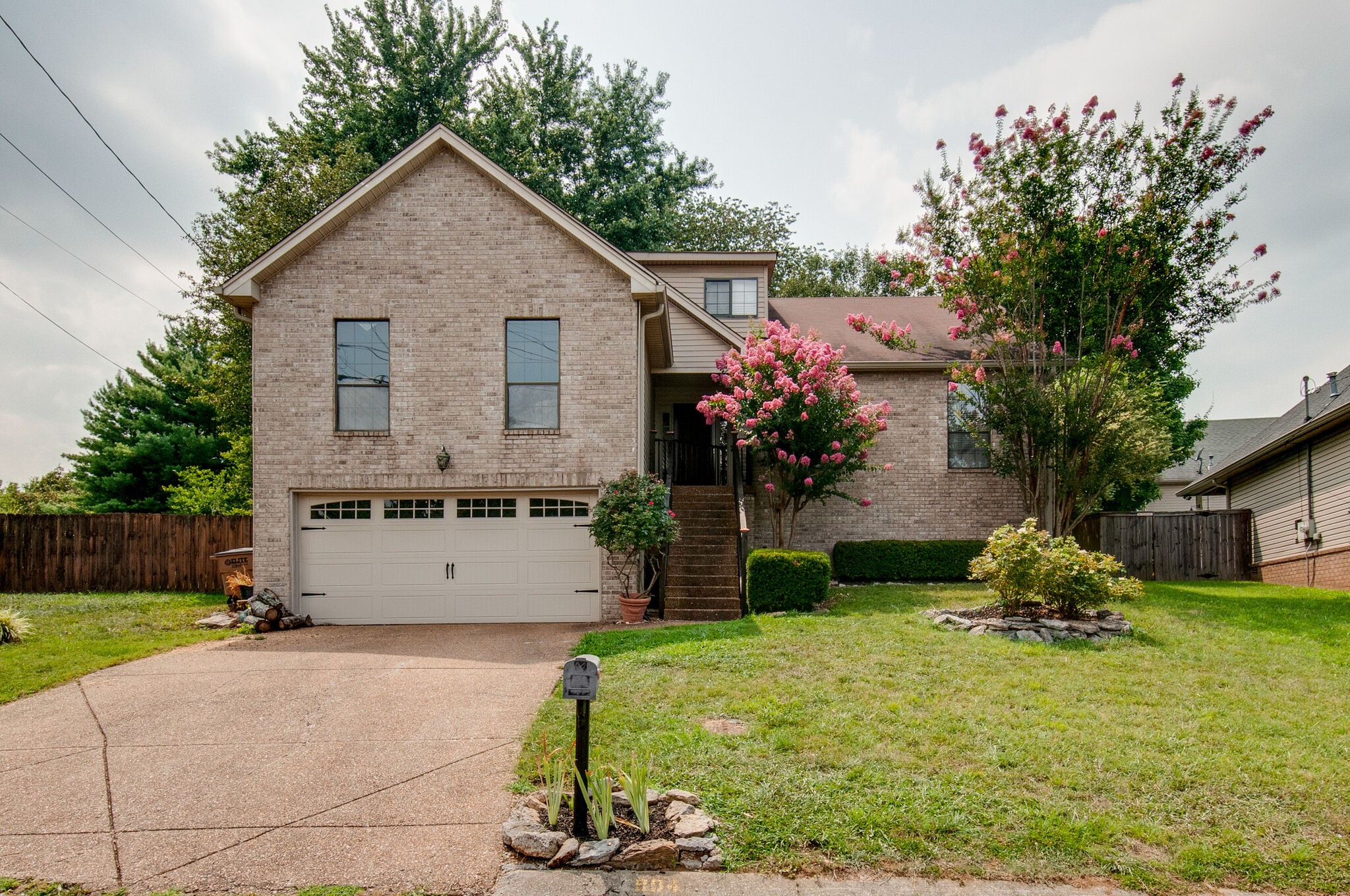a front view of house with yard and trees in the background