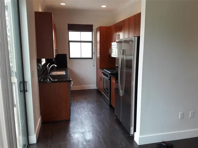 a view of a hallway with wooden floor and windows in a room