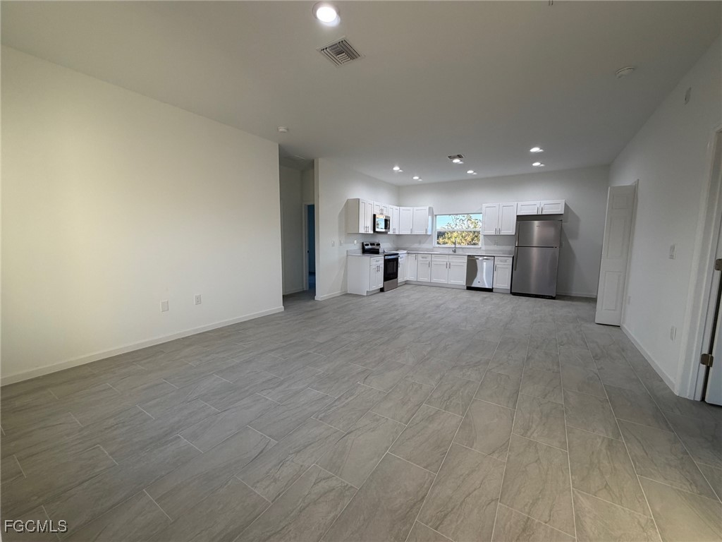 3307 10th Street Southwest Lehigh Acres, FL 33976 - Photo 2 of 13 a view of a kitchen with a sink and a refrigerator