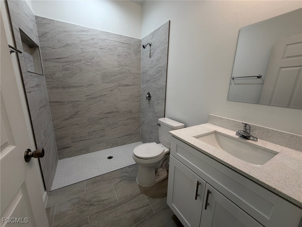 3307 10th Street Southwest Lehigh Acres, FL 33976 - Photo 6 of 13 a bathroom with a granite countertop sink toilet and shower