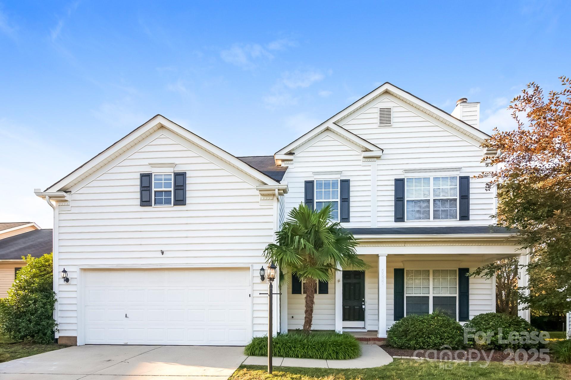 a view of a white house next to a yard