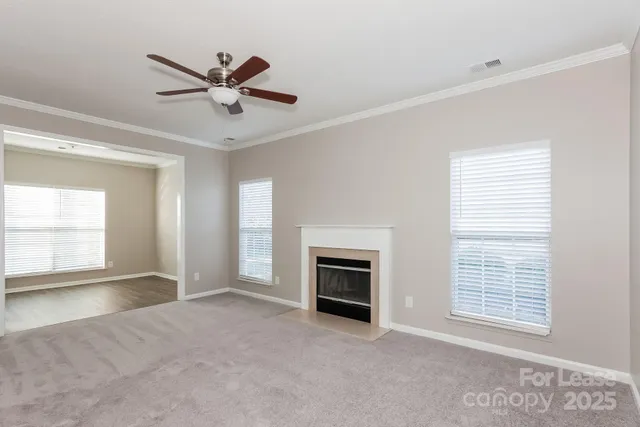 a view of an empty room with a fireplace and a window