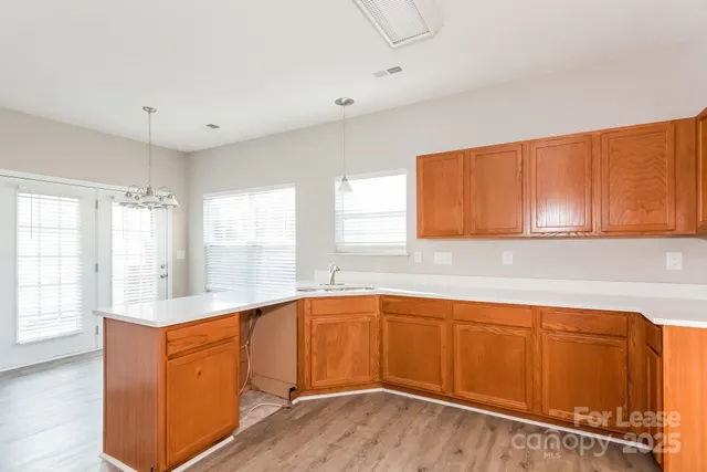 a kitchen with stainless steel appliances granite countertop a sink cabinets and wooden floor