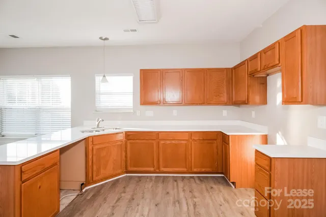 a kitchen with stainless steel appliances granite countertop wooden cabinets a sink and dishwasher with wooden floor