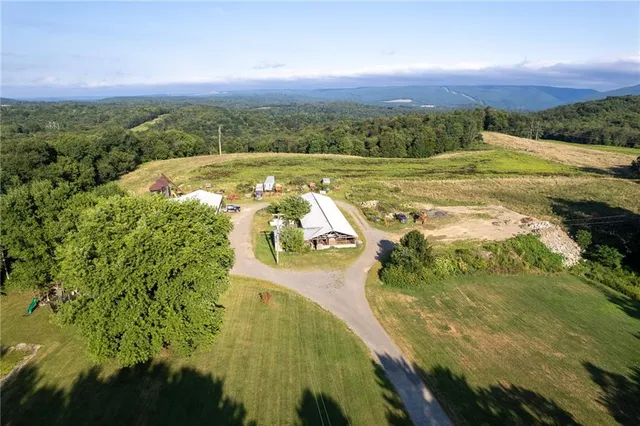 an aerial view of a house with swimming pool and a yard