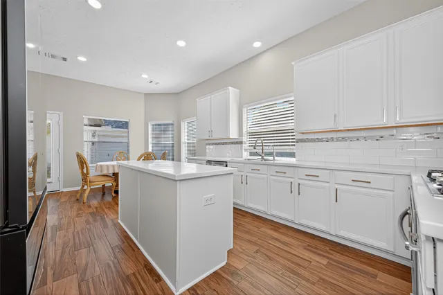 a kitchen with white cabinets appliances and sink