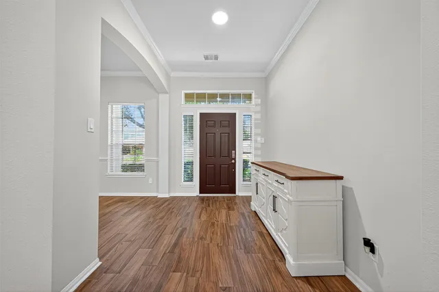 a view of a hallway with wooden floor and staircase