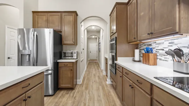 a view of a hallway with wooden floor and a bathroom