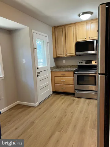 a view of kitchen with wooden floor and electronic appliances