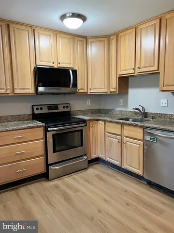 a kitchen with granite countertop a stove a sink and a microwave