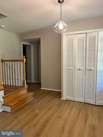 an empty room with wooden floor windows and stairs