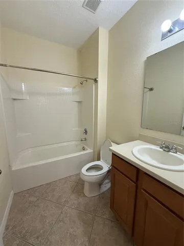 a bathroom with a granite countertop sink a toilet a mirror a bathtub and shower