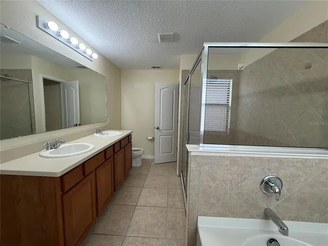 a bathroom with a double vanity sink a mirror and a bathtub