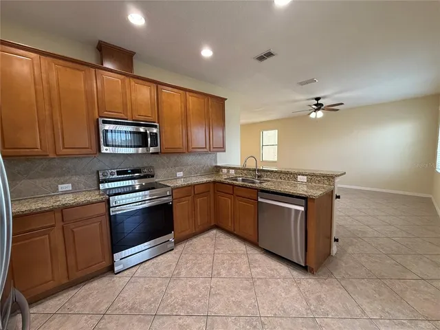 a kitchen with stainless steel appliances granite countertop a sink dishwasher stove and refrigerator
