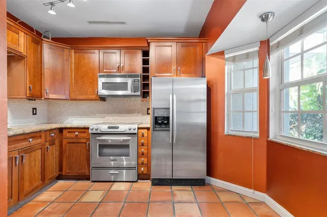 a kitchen with stainless steel appliances granite countertop a refrigerator and a stove