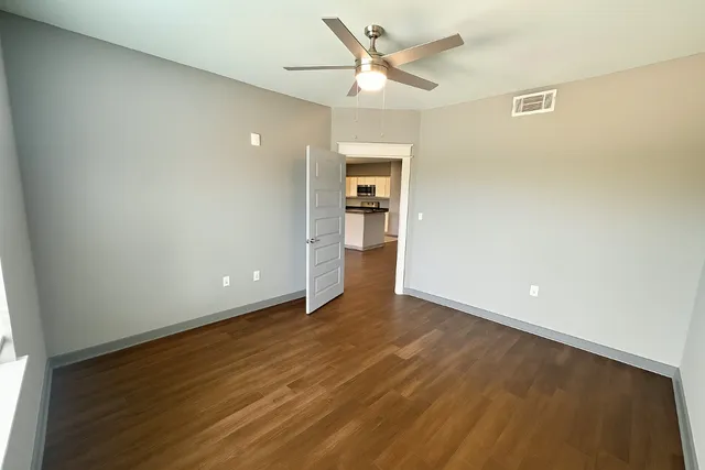 a view of an empty room with wooden floor