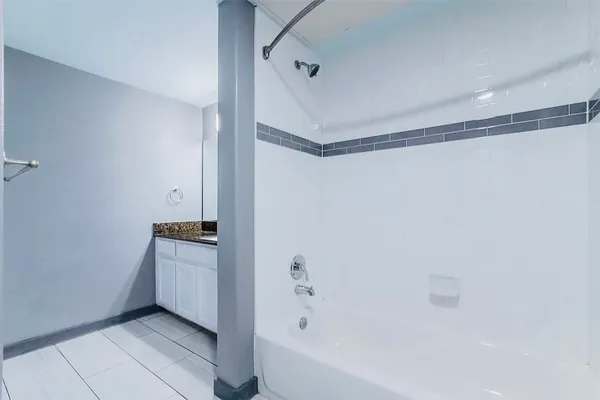 a spacious bathroom with a granite countertop sink a mirror and a shower