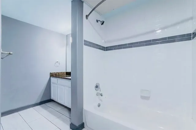 a spacious bathroom with a granite countertop sink a mirror and a shower