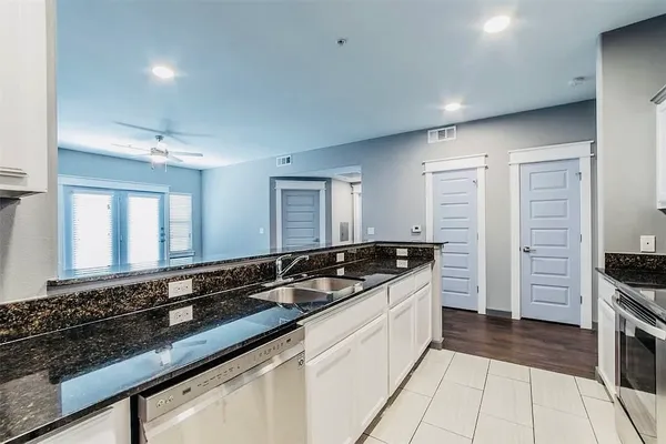 a kitchen with kitchen island granite countertop a stove sink and microwave
