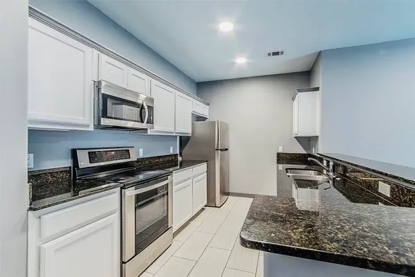 a kitchen with granite countertop a stove and a sink