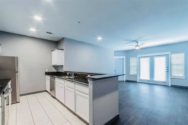 a living room with stainless steel appliances kitchen island wooden floors and view living room