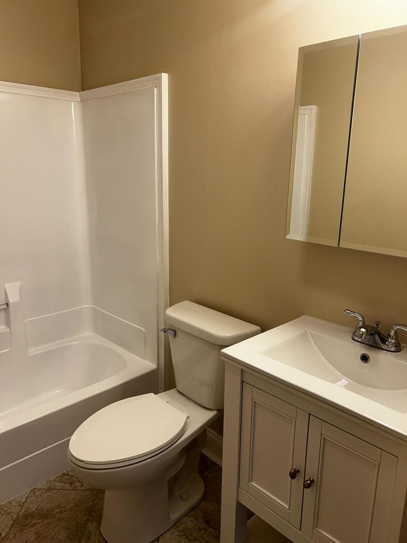 10102 Main Street, Unit 2A Hebron, IL 60034 - Photo 13 of 18 a bathroom with a sink toilet and shower