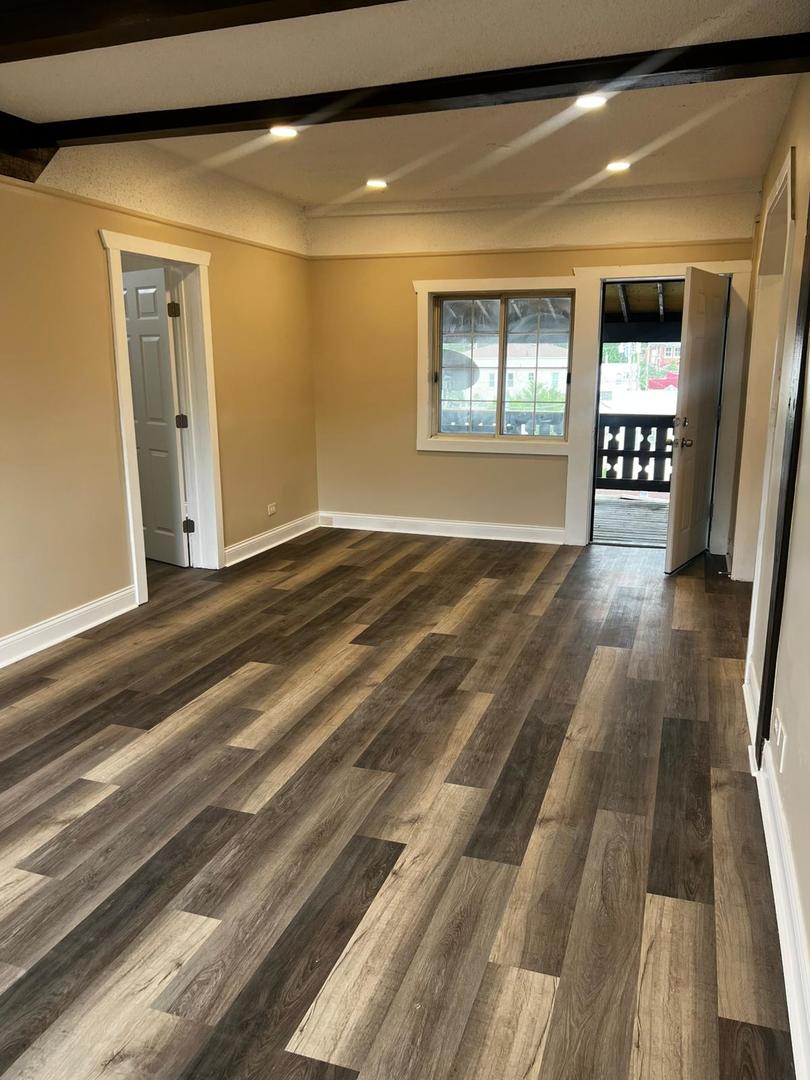 10102 Main Street, Unit 2A Hebron, IL 60034 - Photo 8 of 18 a view of an empty room with window and wooden floor