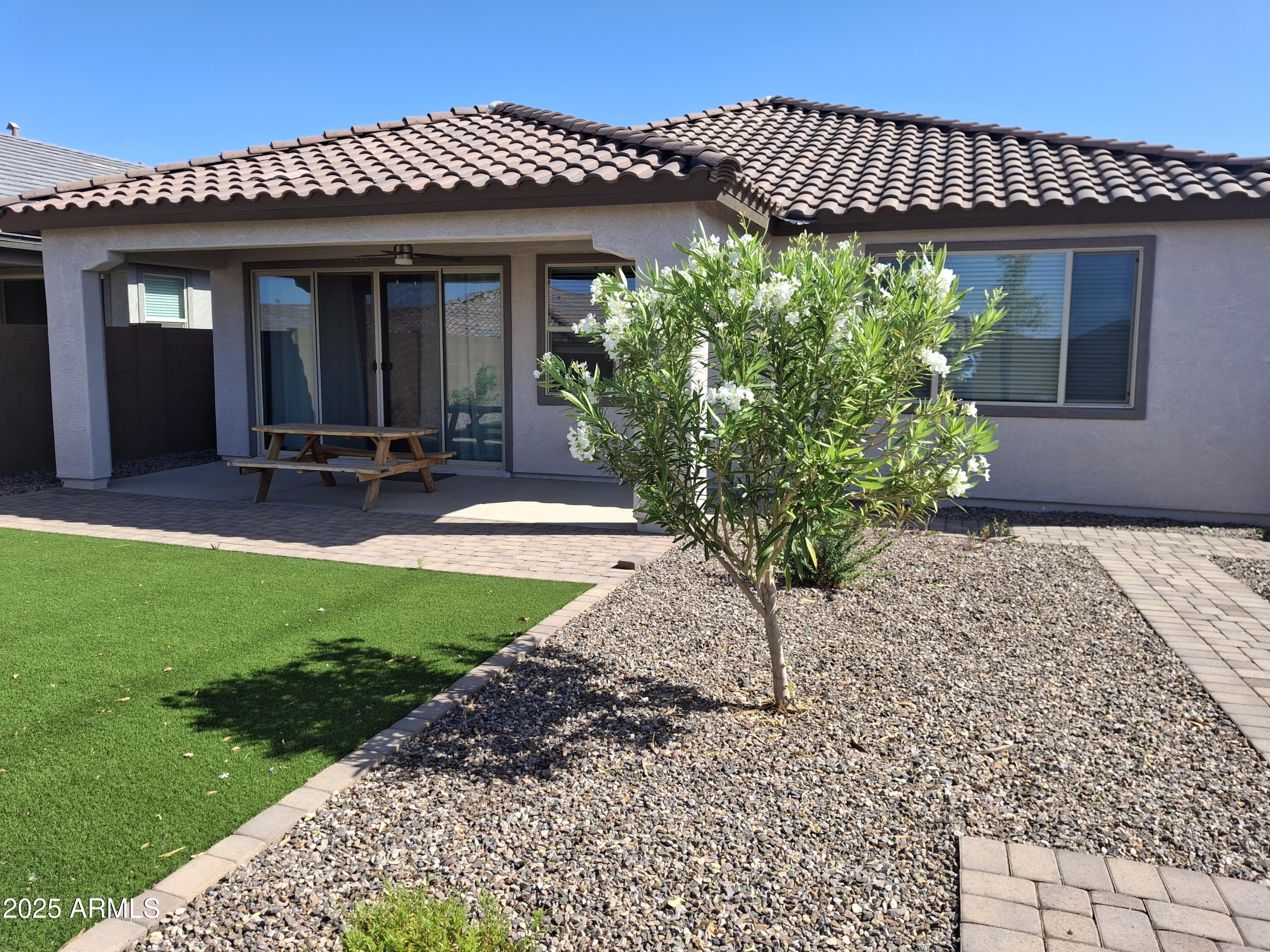 1536 West Corral Road Phoenix, AZ 85041 - Photo 13 of 16 a view of a house with brick walls and a yard with potted plants