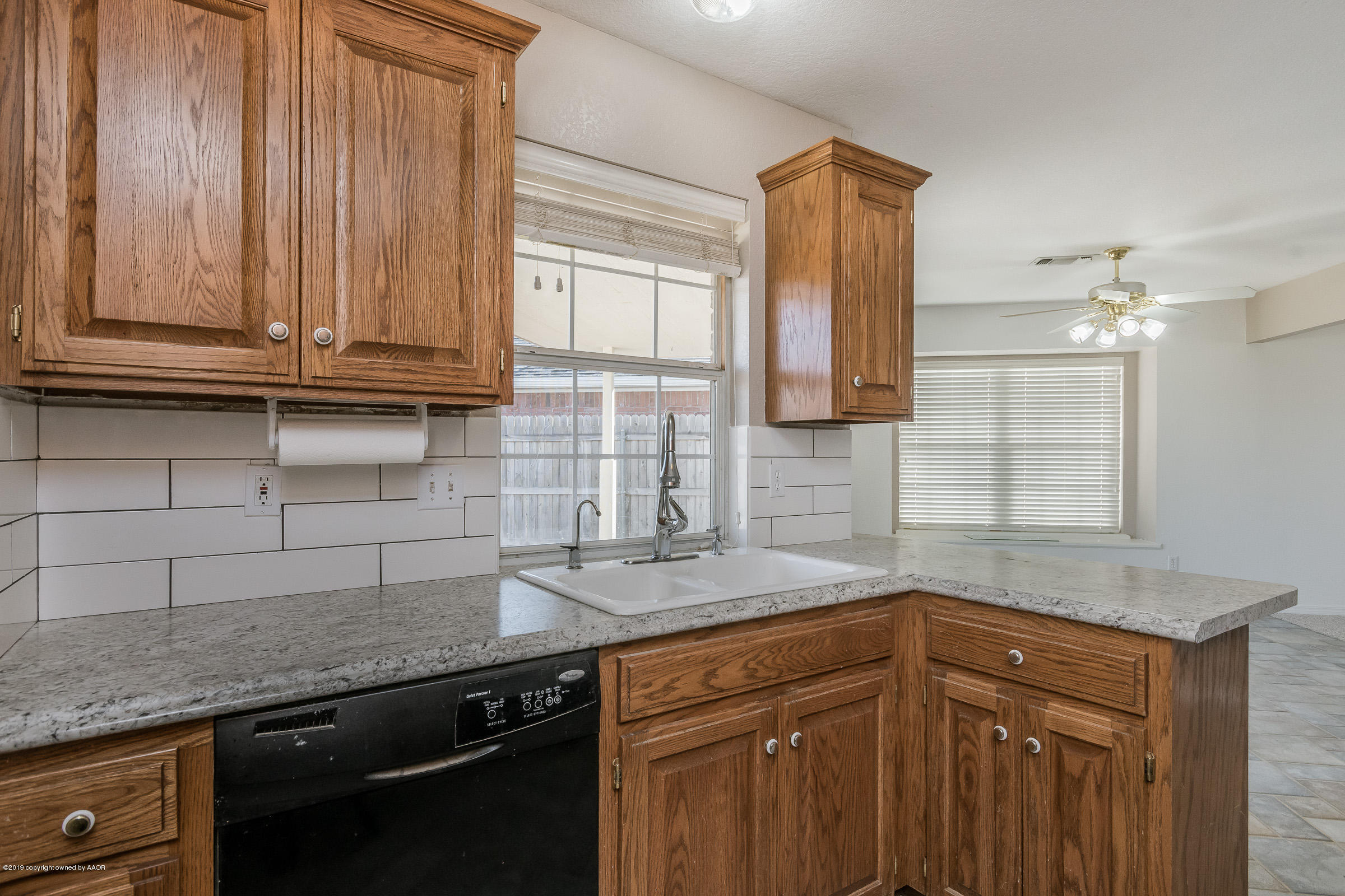 5404 Leo Lane Amarillo, TX 79110 - Photo 8 of 20 a kitchen with granite countertop a sink and a wooden cabinets