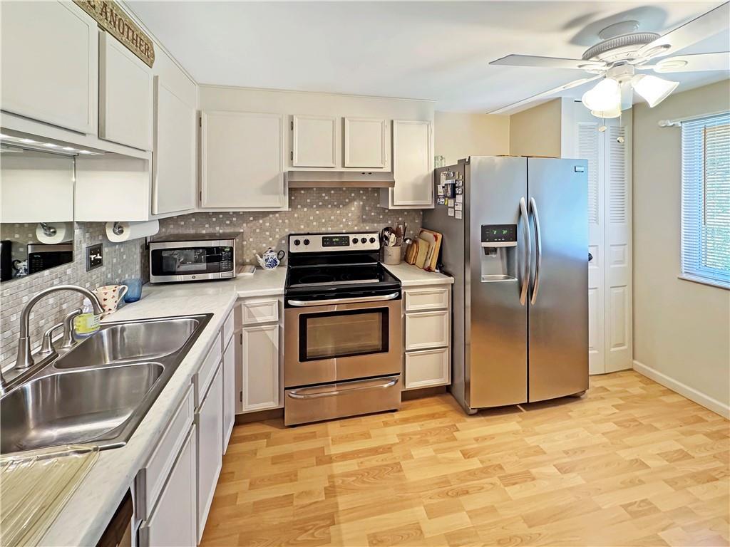 2303 Firethorn Road Bridgeville, PA 15017 - Photo 8 of 25 The eat-in kitchen features white cabinetry and a pantry.