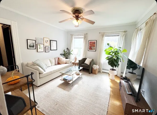 a living room with furniture a chandelier and a window