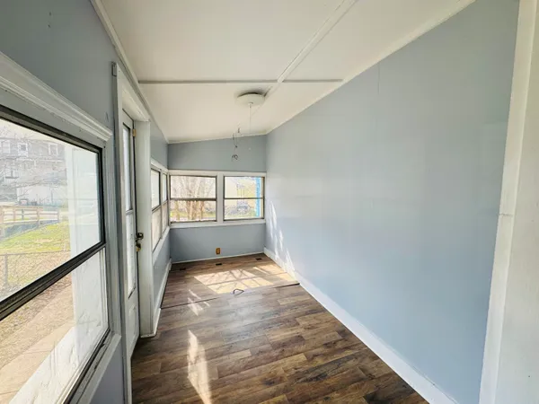 a view of a big room with wooden floor and windows