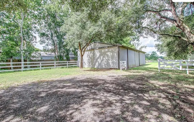 a view of a house with backyard and trees