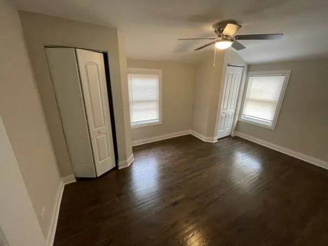 an empty room with wooden floor and window