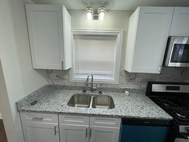 a kitchen with granite countertop a sink dishwasher and cabinets