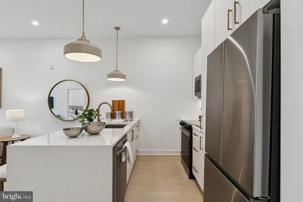 a kitchen with stainless steel appliances granite countertop a sink a refrigerator and a stove