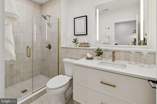 a bathroom with a granite countertop sink toilet and shower