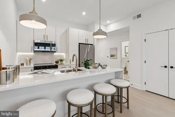 a kitchen with stainless steel appliances a dining table chairs and a chandelier