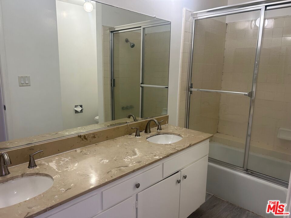 1440 Reeves Street, Unit 105 Los Angeles, CA 90035 - Photo 5 of 9 a bathroom with a granite countertop sink and a mirror