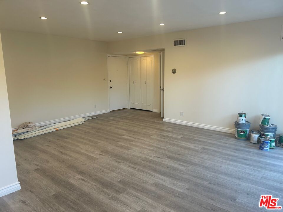 1440 Reeves Street, Unit 105 Los Angeles, CA 90035 - Photo 7 of 9 an empty room with wooden floor and furniture