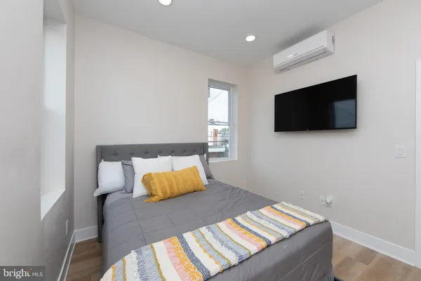 a living room with a bed and a flat screen tv